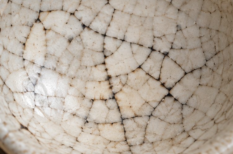 Weiße Glasur mit einem feinen Netz schwarzer Craquelé-Risse